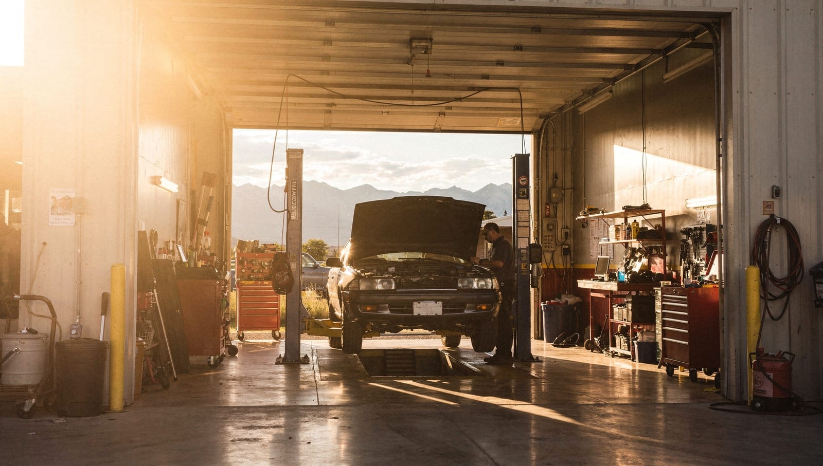 Sunlight pours through the open bay door at Ernie's, a car up on the lift
